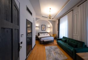 伊斯坦布尔Ferman Port Hotel - Special Category的客厅配有绿色沙发和床。