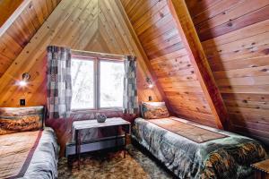 西优胜美地Stoneoaks的小木屋内一间卧室,配有两张床