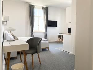 美茵河畔哈瑙Best Boarding House的酒店客房配有一张床和一张带椅子的书桌
