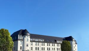 美茵河畔哈瑙Best Boarding House的黑色屋顶的白色大建筑