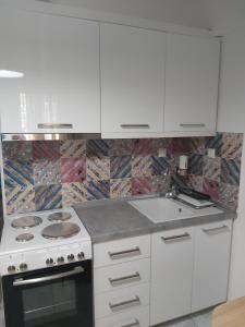 塞雷Lux apartment downtown的白色的厨房配有炉灶和水槽