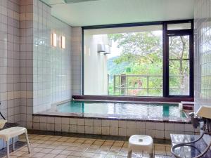 Kami玉莫诺温泉日式旅馆的一间带游泳池及窗户的浴室