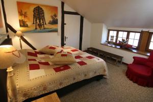斯塔沃洛Gîte La Grande Francorchamps Ardennaise的一间卧室配有一张床和一张红色椅子