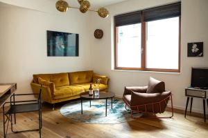 柏林Urbn Dreams II的客厅配有黄色沙发和两把椅子