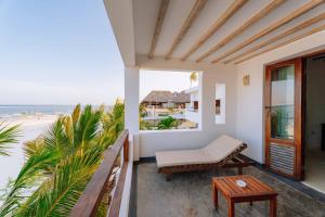 马特姆维La Villa de Victor Kigomani的阳台设有长凳,享有海滩美景。