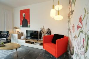 圣若里奥Le Saint-Jore - 2 bedroom apartment balcony & parking的客厅配有红色椅子和电视