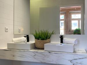 波尔图Lost Inn Porto Hostel的白色的浴室设有两个盥洗盆和镜子