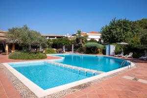 巴里萨尔多拉托雷酒店的一座大型游泳池,位于一个与度假村的庭院内