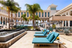 阿尔卡拉Gran Melia Palacio de Isora Resort & Spa的建筑物前的一排蓝色躺椅