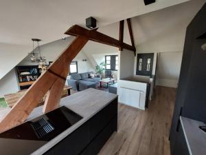 VierlingsbeekB&B Vierlingsbeek, Appartement Onder één dak en tuin-chalet的厨房和带大型木梁的客厅