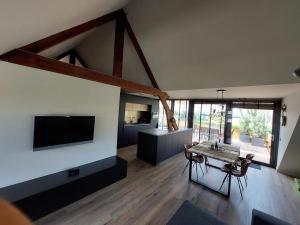 VierlingsbeekB&B Vierlingsbeek, Appartement Onder één dak en tuin-chalet的大型客厅配有桌子和电视