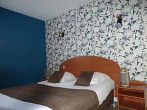 布雷叙尔LOGIS Hôtel LES 3 MARCHANDS的一间卧室设有两张床和花卉壁纸