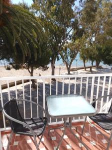 圣卡洛斯拉腊皮塔La Vela al Vent apartamentos的海滩阳台的一张桌子和两把椅子