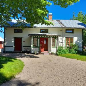 TorsåkerMagasinet的一间白色的房子,有红色的门和车道