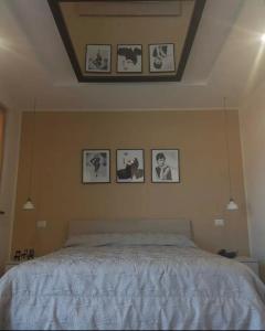 奥塔维亚诺Amy Dreams的卧室配有一张墙上挂有照片的床