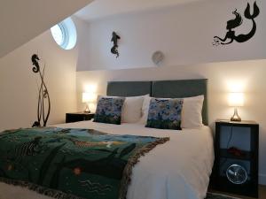 布里克瑟姆Starboard Side Brixham - Ideal seaside getaway with parking的一间卧室配有一张大床和两盏灯。