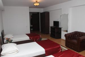 UrziceniHotel Royal 2的酒店客房,配有两张床和椅子