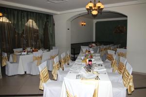 UrziceniHotel Royal 2的一间设有白色桌椅的用餐室