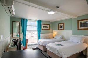 迪尔克拉伦登酒店 的客房设有两张床、一张桌子和一扇窗户。