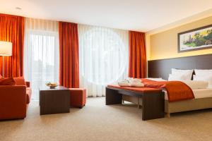 ErbendorfAribo Hotel的配有一张床和一把椅子的酒店客房
