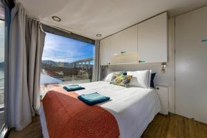 波尔图Oporto Douro Floating House的一间卧室设有一张大床和大窗户