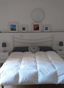 克里日亚Residenza Solferino的卧室内的一张白色床,配有两盏灯和镜子