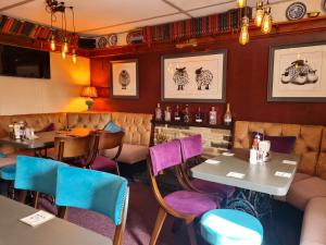 里士满Bolton arms downholme的餐厅设有紫色和蓝色的椅子和桌子