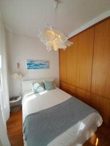 波尔图Comfortable Central 2 Bedrooms Apartments by Great&Cosy的一间卧室配有一张床和一个吊灯