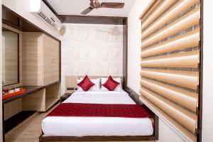 班加罗尔FabHotel The Leela Park的一间卧室配有一张带红色枕头的大床