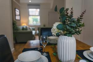 利明顿温泉Villiers House - Comfy Stylish Home的一张桌子,上面有花花白花瓶