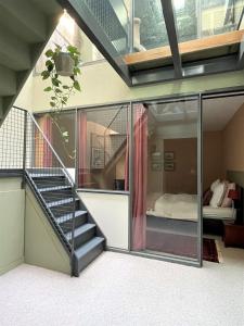 巴黎Maison exceptionnelle, Campagne a Paris的玻璃房子,设有楼梯和床