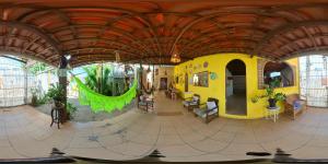 纳塔尔Jambudvipa Hostel的大房间,设有黄色建筑和木制天花板