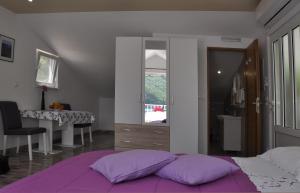 OkukljeApartment Danijela的一间卧室配有一张带紫色枕头的床和一张书桌