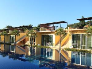 邦波BANGKOK.GRAND.RESORT的一座棕榈树环绕的游泳池建筑