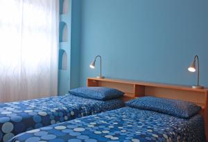 的里雅斯特Edera Residence的蓝色墙壁客房的两张床