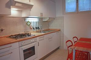 的里雅斯特Edera Residence的厨房配有白色橱柜和炉灶烤箱。