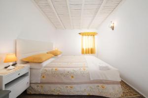 奥德赛克斯Casa Morais的一间白色卧室,配有一张床和一个梳妆台