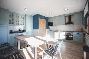 马德里Casa Rural Sierra Oeste的厨房配有蓝色橱柜和桌椅