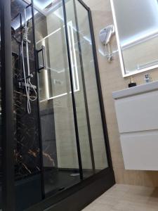 奥斯特罗文卡"Arkadia"的浴室里设有玻璃门淋浴