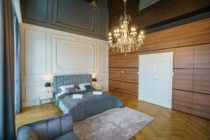 凯尔采Prestige Apartment Rynek Kielce的一间卧室配有一张床和一个吊灯