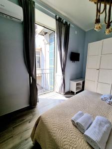 那不勒斯DUOMO 152 NAPOLI的一间卧室设有一张床和一个阳台的窗户。