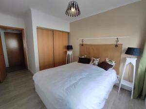 蓬塔德尔加达City Apartament的卧室配有一张白色大床和两盏灯。
