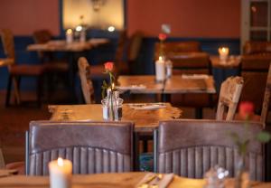 Lauder布莱克布尔酒店的餐厅设有木桌、椅子和蜡烛
