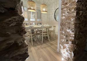 安波拉Arrels apartaments的一间设有桌子和石墙的用餐室
