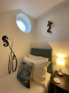 布里克瑟姆Starboard Side Brixham - Ideal seaside getaway with parking的一间卧室配有一张带窗户和灯的床