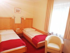 萨尔茨堡佩西恩凯特琳旅馆的酒店客房,配有两张床和椅子