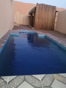 Al Rakaشاليهات رمال بديه的院子里的大型蓝色游泳池