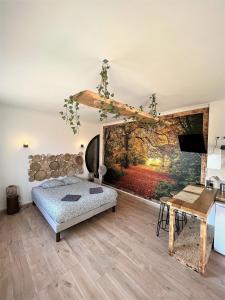 圣艾尼昂Balade en Forêt, 3min du Zoo的卧室配有一张床,墙上挂有绘画作品