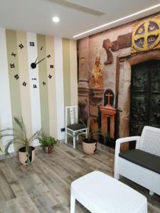 BaleiraPENSION PORTA SANTA的客厅墙上挂着时钟