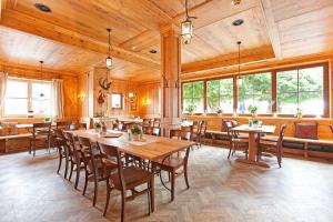 施坦贝尔格湖畔贝格奥夫基辛POST酒店的用餐室配有木桌和椅子